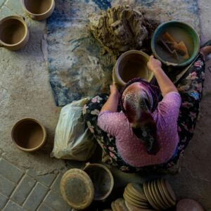 A skilled artisan crafting pottery using traditional methods viewed from above.