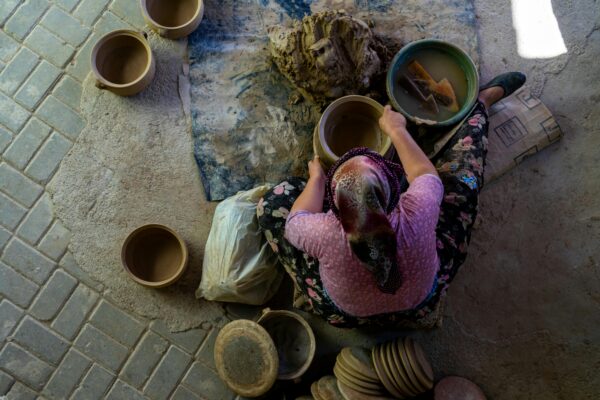 A skilled artisan crafting pottery using traditional methods viewed from above.